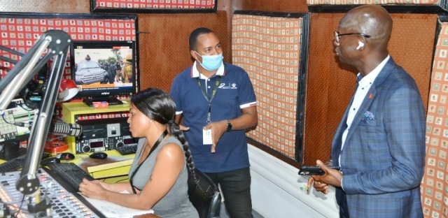 Radio One sports editor Amri Massare (C) introduces the guest to operations in one of the station’s radio studios.